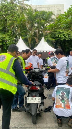 Peserta defensive riding training melakukan pre-trip inspection sepeda motor sebelum sesi praktik.