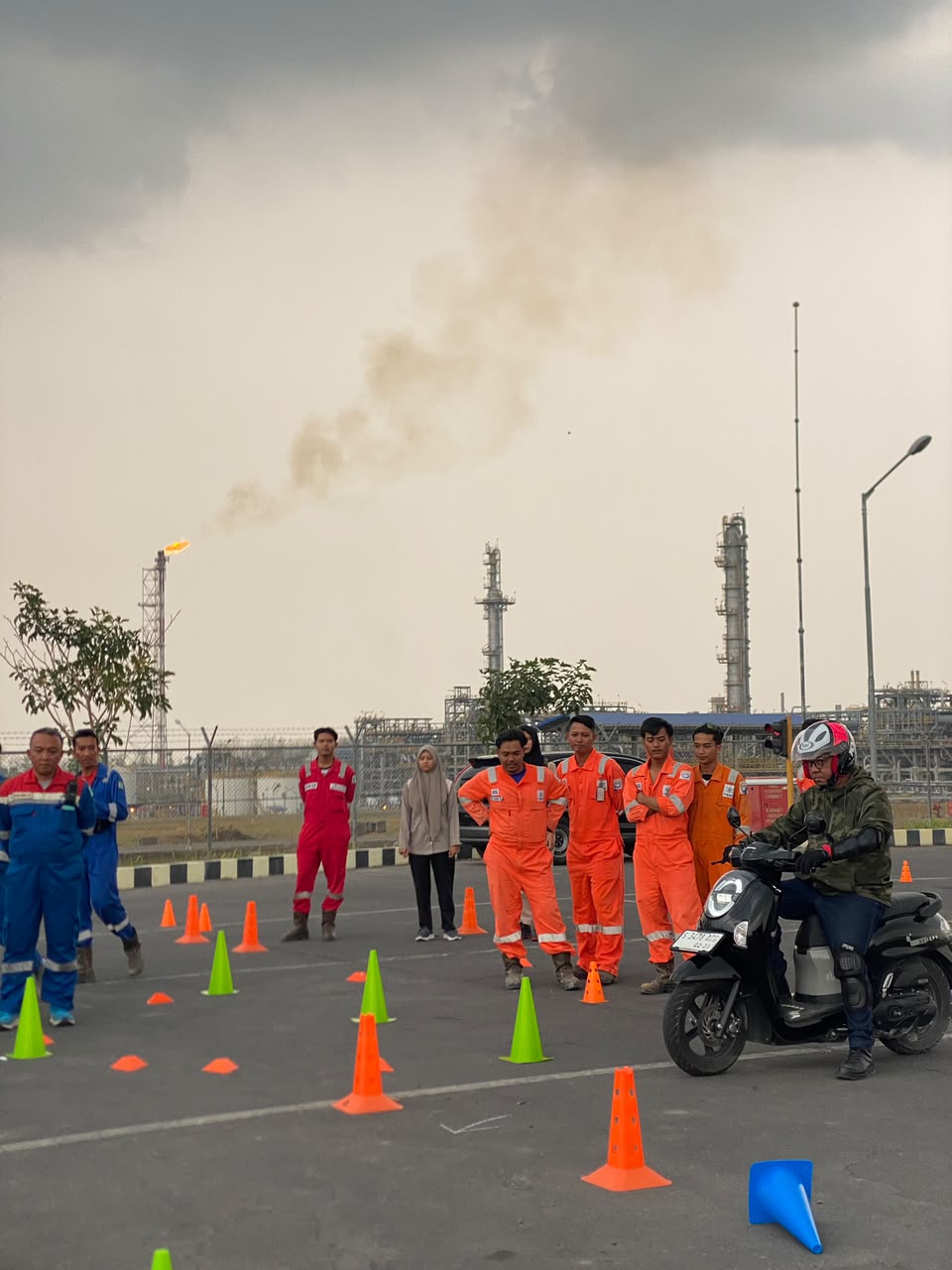 Pengendara bermotor melintasi cone penanda sementara peserta lain mengamati demonstrasi di area terbuka PEPC Site JTB
